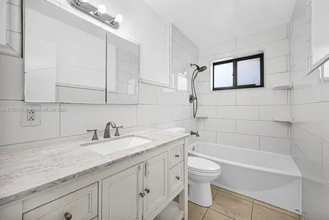 a bathroom with a granite countertop sink a toilet and bathtub