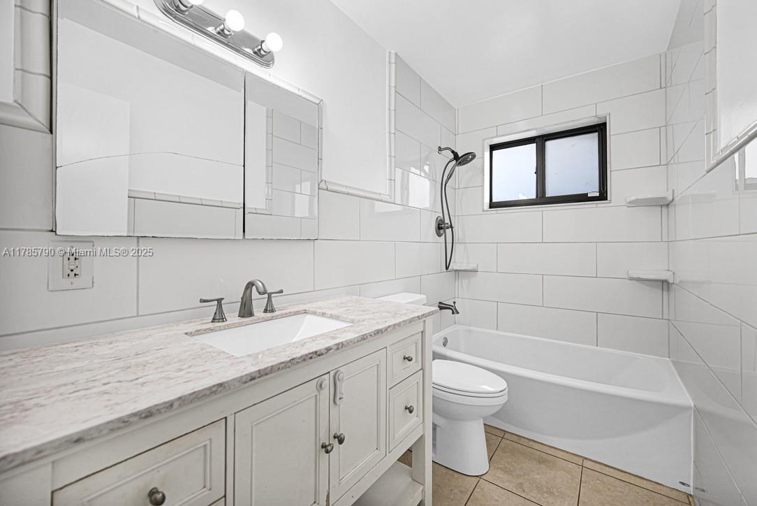 8451 Northwest 10th Street Pembroke Pines, FL 33024 - Photo 22 of 32 a bathroom with a granite countertop sink a toilet and bathtub
