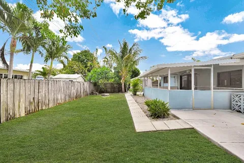 a view of a house with backyard and sitting area