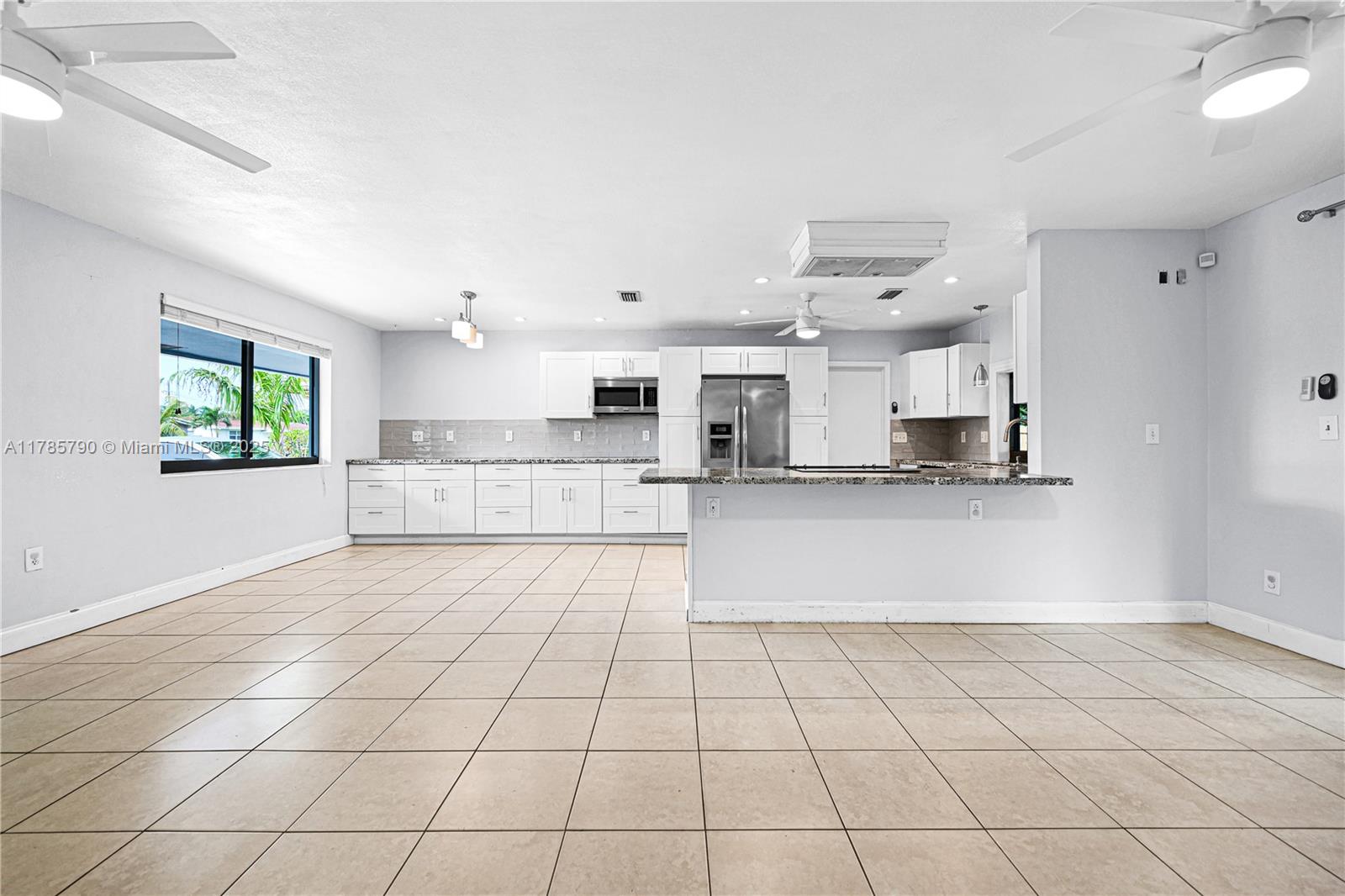 8451 Northwest 10th Street Pembroke Pines, FL 33024 - Photo 9 of 32 a large white kitchen with a stove a sink dishwasher and a refrigerator