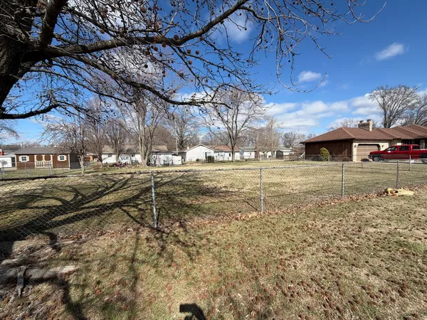 a view of a yard with wooden fence