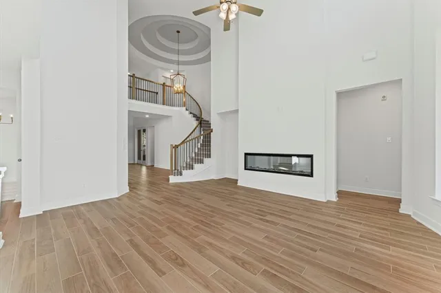 a view of a livingroom with wooden floor and a hallway