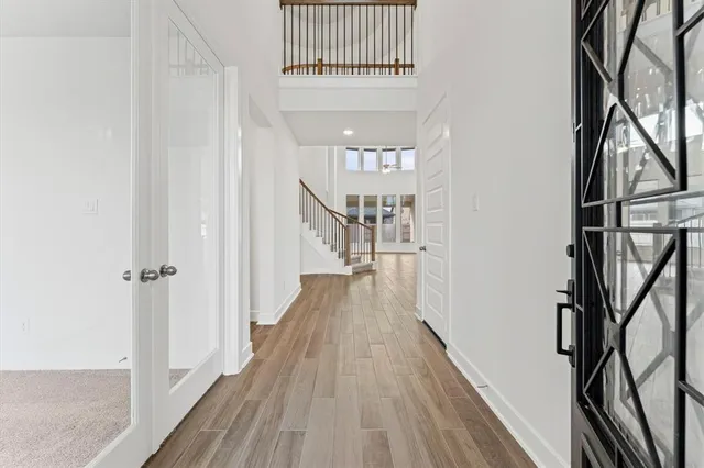 a view of a hallway with wooden floor and staircase