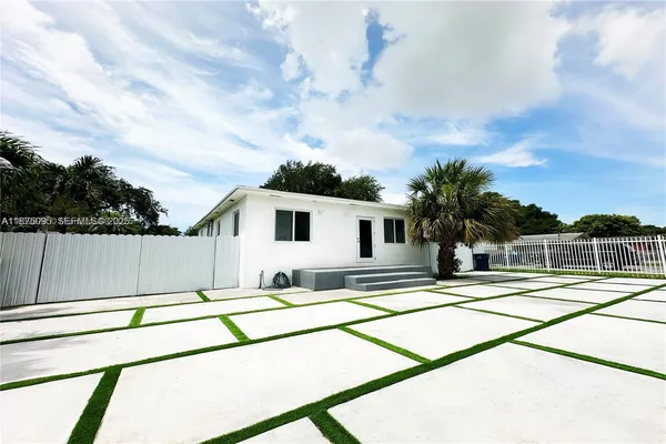 a view of a terrace with a bench and palm trees