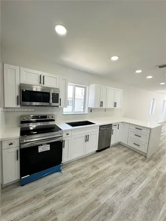 a kitchen with kitchen island sink and cabinets