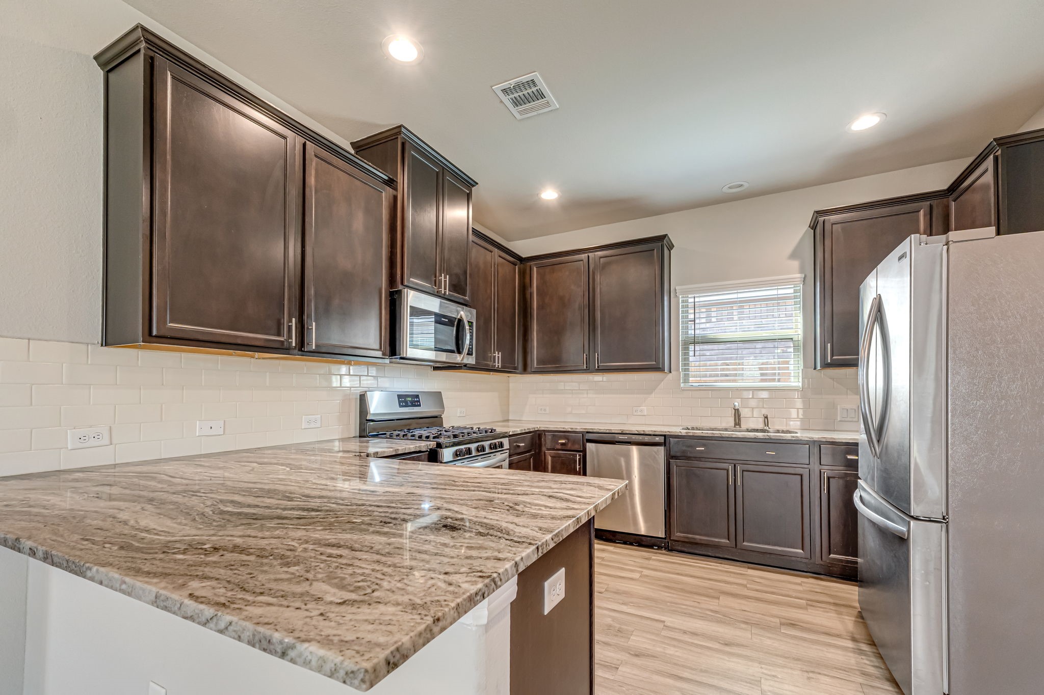 10314 Birch Peak Drive Rosharon, TX 77583 - Photo 11 of 38 a kitchen with stainless steel appliances granite countertop a sink stove and refrigerator