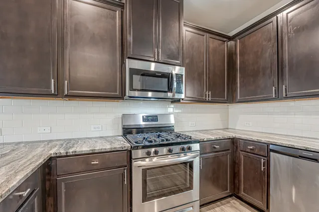 a kitchen with granite countertop cabinets stainless steel appliances and wooden cabinets