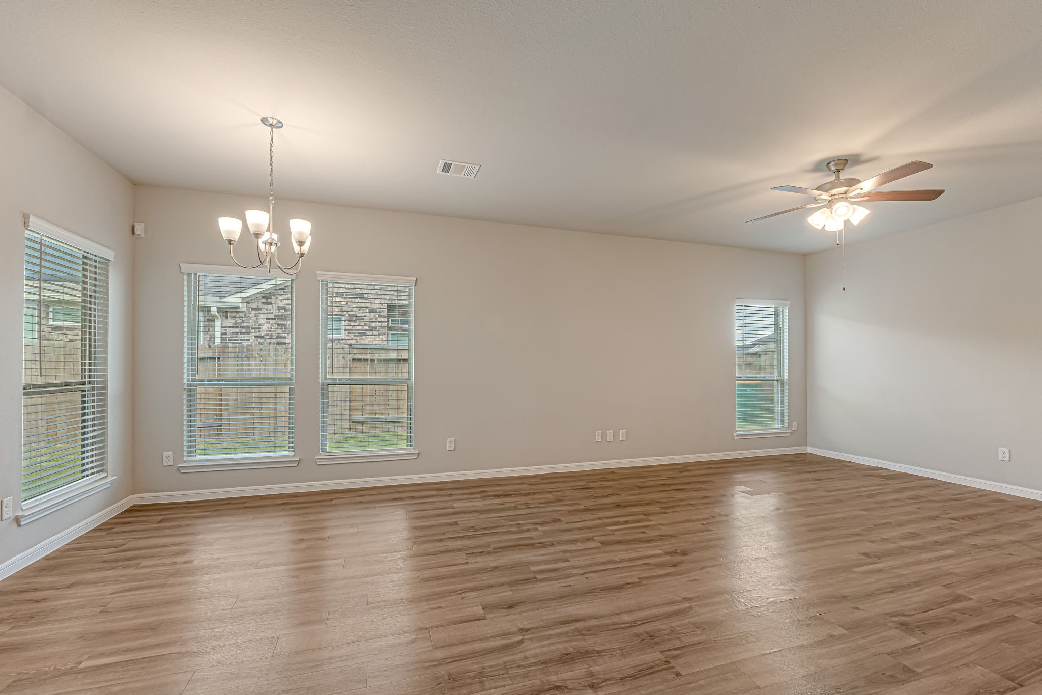 10314 Birch Peak Drive Rosharon, TX 77583 - Photo 7 of 38 an empty room with wooden floor chandelier fan and windows
