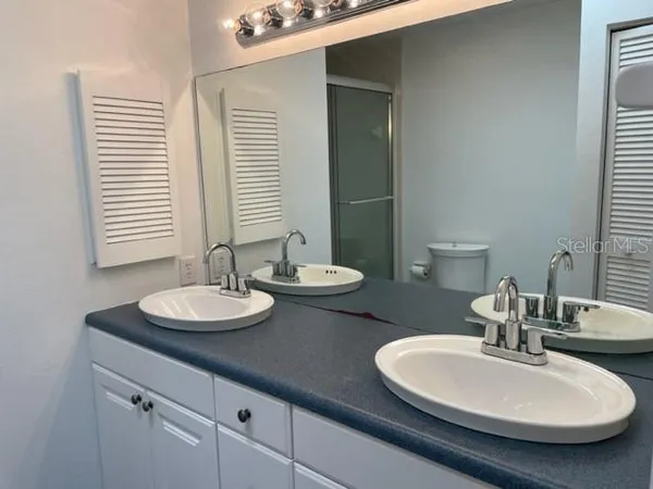 a bathroom with a double vanity sink and a mirror