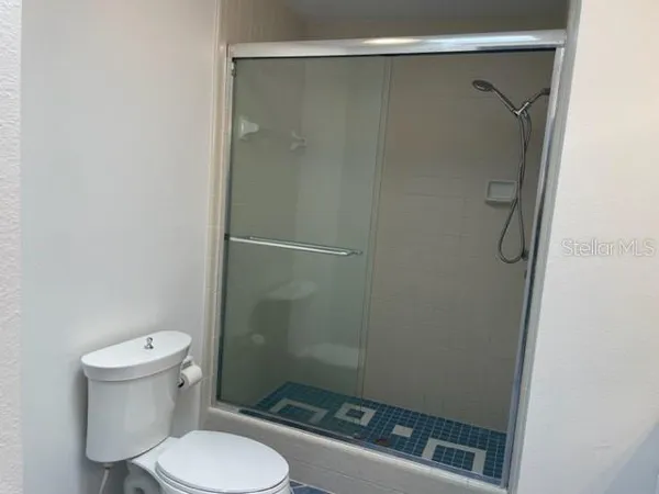 a bathroom with a toilet and a shower
