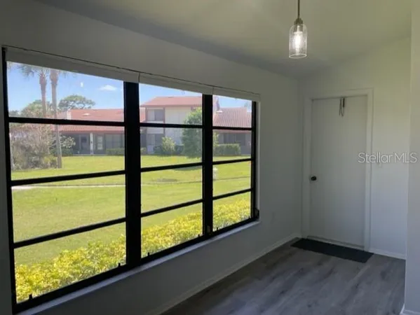 a view of hallway with a large window and wooden floor