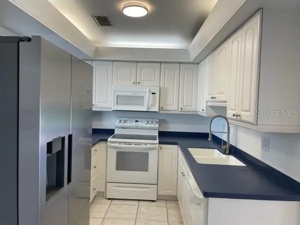 a kitchen with appliances a sink and cabinets
