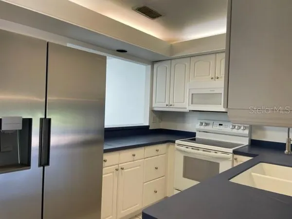 a kitchen with stainless steel appliances granite countertop a refrigerator sink and cabinets