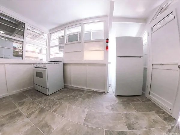 a kitchen with white cabinets and refrigerator