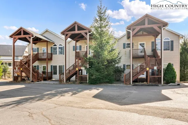a view of a white house with a yard and lake view