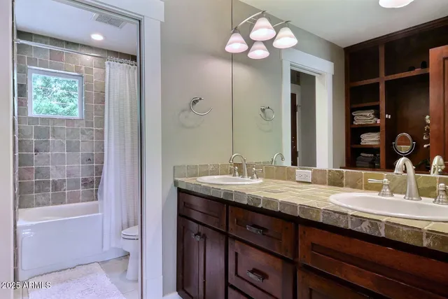 a bathroom with a granite countertop sink a large mirror and a bathtub