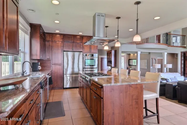 a kitchen with stainless steel appliances granite countertop a sink a stove and a refrigerator