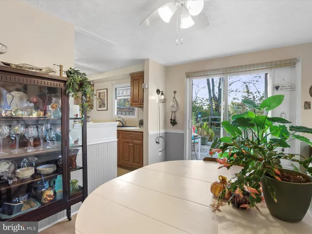 a kitchen with stainless steel appliances a large window a dining table and chairs