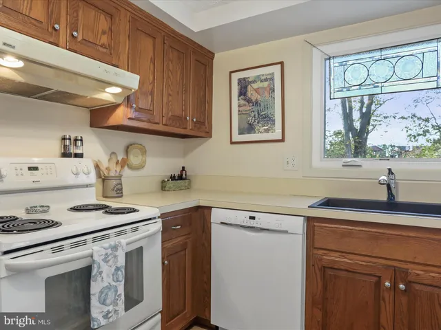 a kitchen with stainless steel appliances white cabinets and a stove top oven