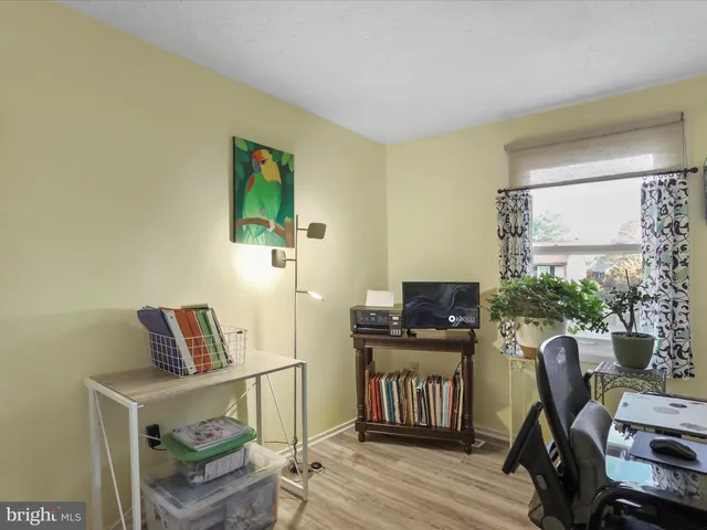 a view of a workspace with furniture and a window