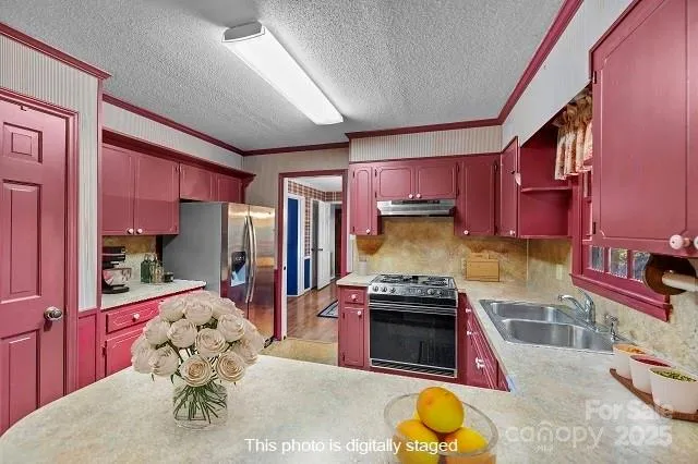a kitchen with stainless steel appliances granite countertop a stove a sink and a refrigerator
