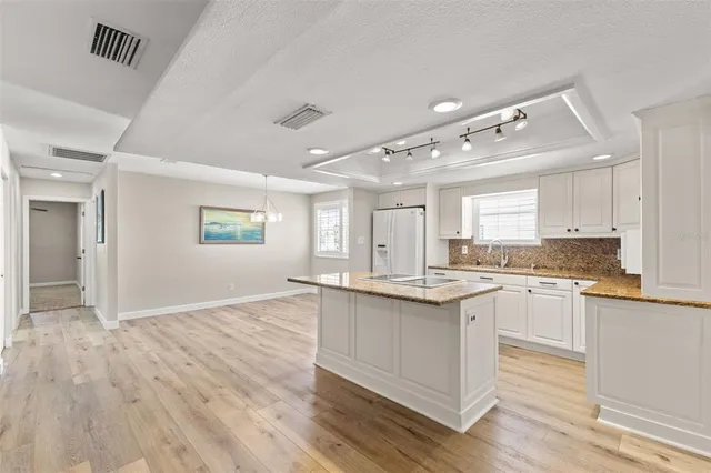 a kitchen with kitchen island white cabinets and white appliances