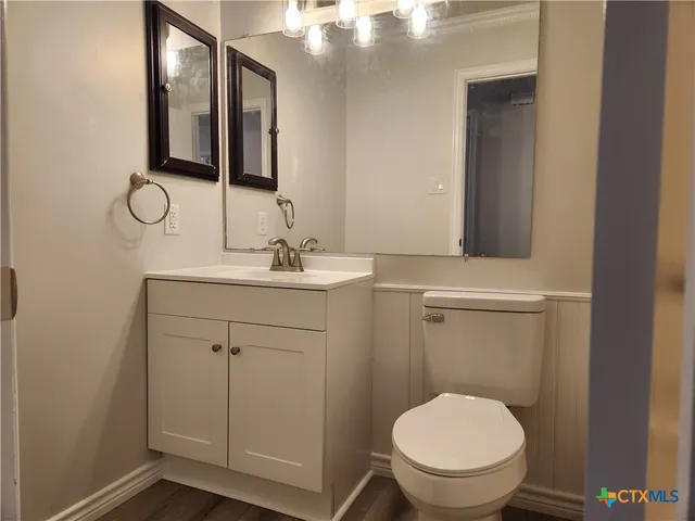 a bathroom with a toilet sink and mirror