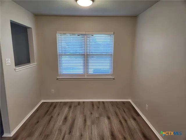 a view of a room with wooden floor and window