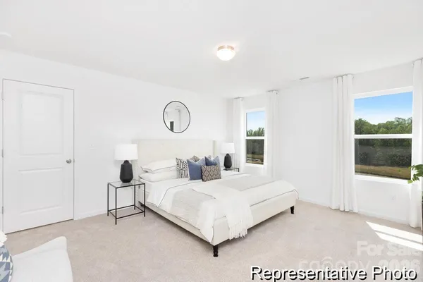a bedroom with a bed and white wall painting
