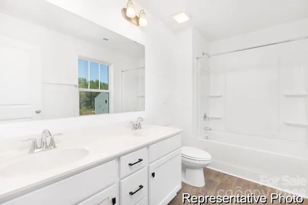 a bathroom with a granite countertop sink a toilet and a bathtub