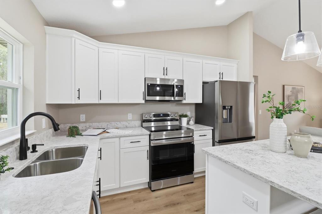 3671 East Ryan Street Inverness, FL 34453 - Photo 15 of 48 a kitchen with refrigerator a stove a sink and a microwave