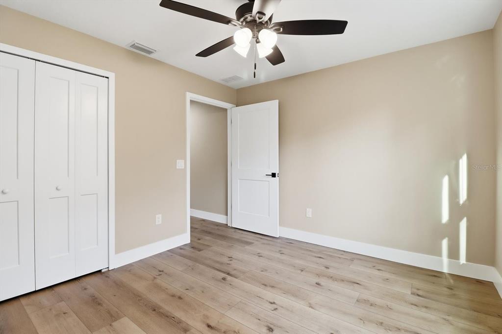3671 East Ryan Street Inverness, FL 34453 - Photo 27 of 48 an empty room with wooden floor chandelier fan and closet area