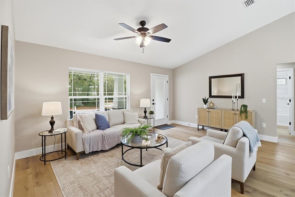 3671 East Ryan Street Inverness, FL 34453 - Photo 10 of 48 a living room with furniture floor to ceiling window and a potted plant