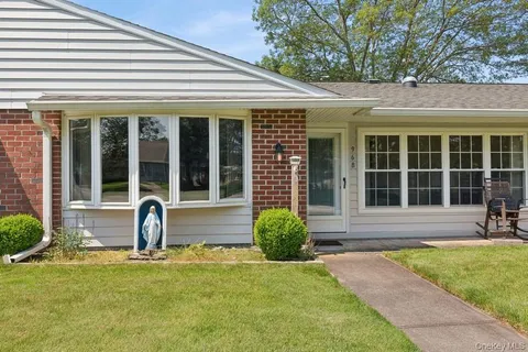a front view of a house with garden and patio