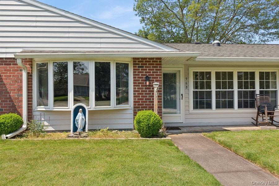 96 Enfield Court, Unit B Ridge, NY 11961 - Photo 1 of 22 a front view of a house with garden and patio