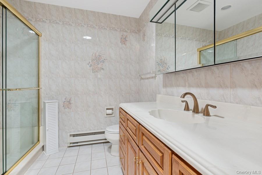 96 Enfield Court, Unit B Ridge, NY 11961 - Photo 14 of 22 a bathroom with a sink a toilet and shower
