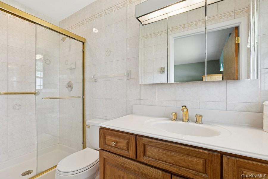 96 Enfield Court, Unit B Ridge, NY 11961 - Photo 18 of 22 a bathroom with a sink a toilet and shower