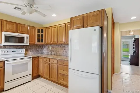 a view of a kitchen with a sink a refrigerator and cabinets