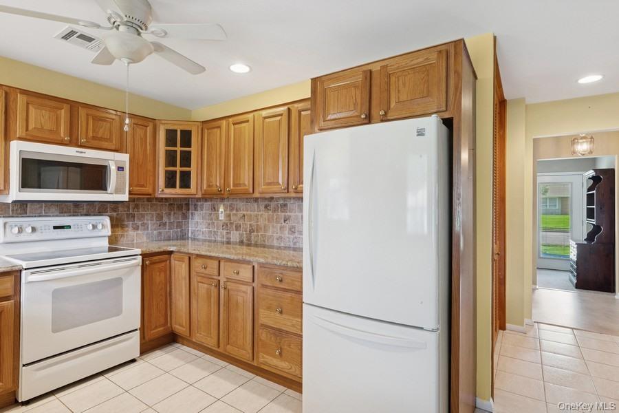 96 Enfield Court, Unit B Ridge, NY 11961 - Photo 6 of 22 a view of a kitchen with a sink a refrigerator and cabinets