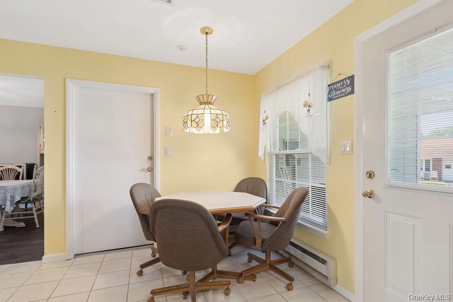 96 Enfield Court, Unit B Ridge, NY 11961 - Photo 8 of 22 a view of a dining room with furniture window and wooden floor