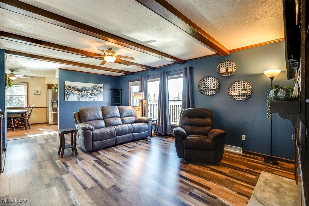 1157 Bass Circle Northwest Canton, OH 44708 - Photo 6 of 31 Living room featuring visible vents, beamed ceiling, a textured ceiling, and wood finished floors