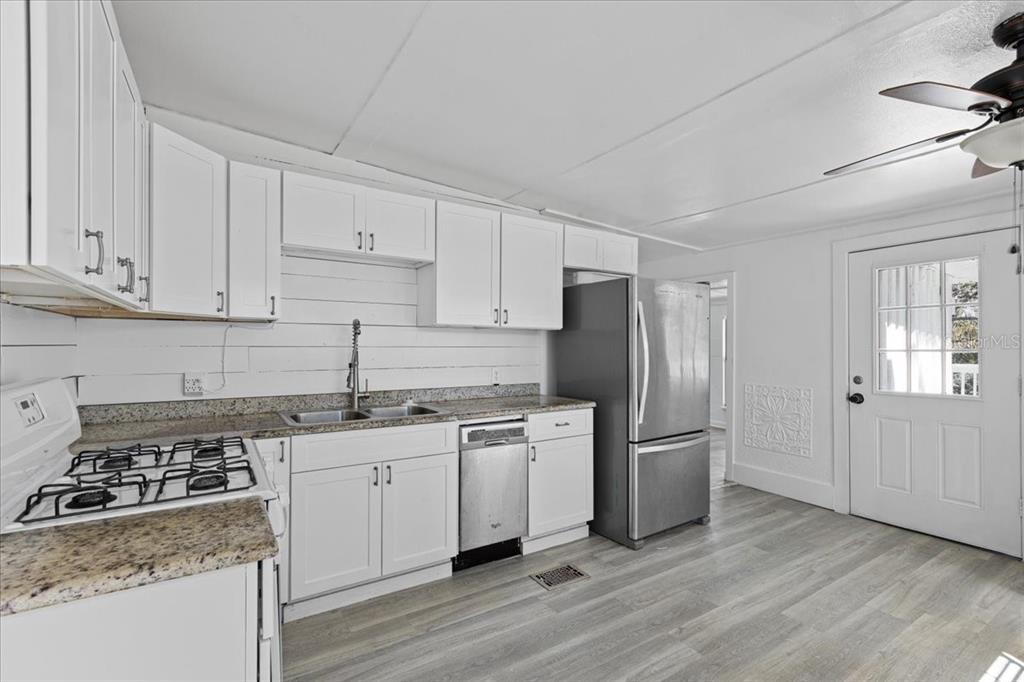 1149 Shell Crest Avenue Cedar Key, FL 32625 - Photo 14 of 32 a kitchen with a stove a sink and a refrigerator
