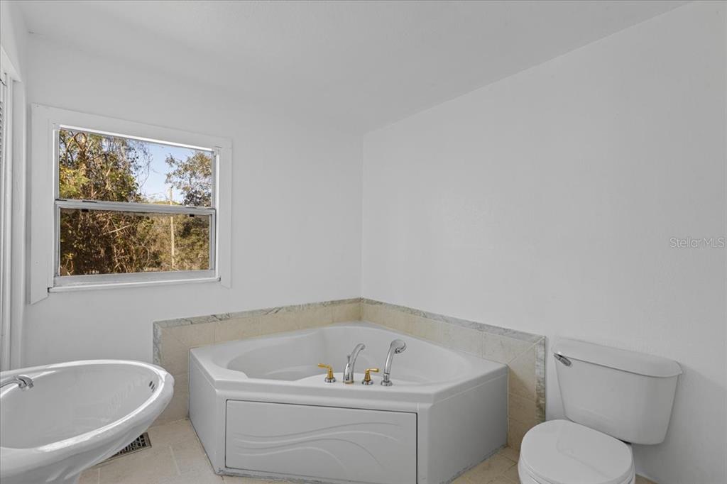 1149 Shell Crest Avenue Cedar Key, FL 32625 - Photo 17 of 32 a white bath tub sitting next to a white toilet