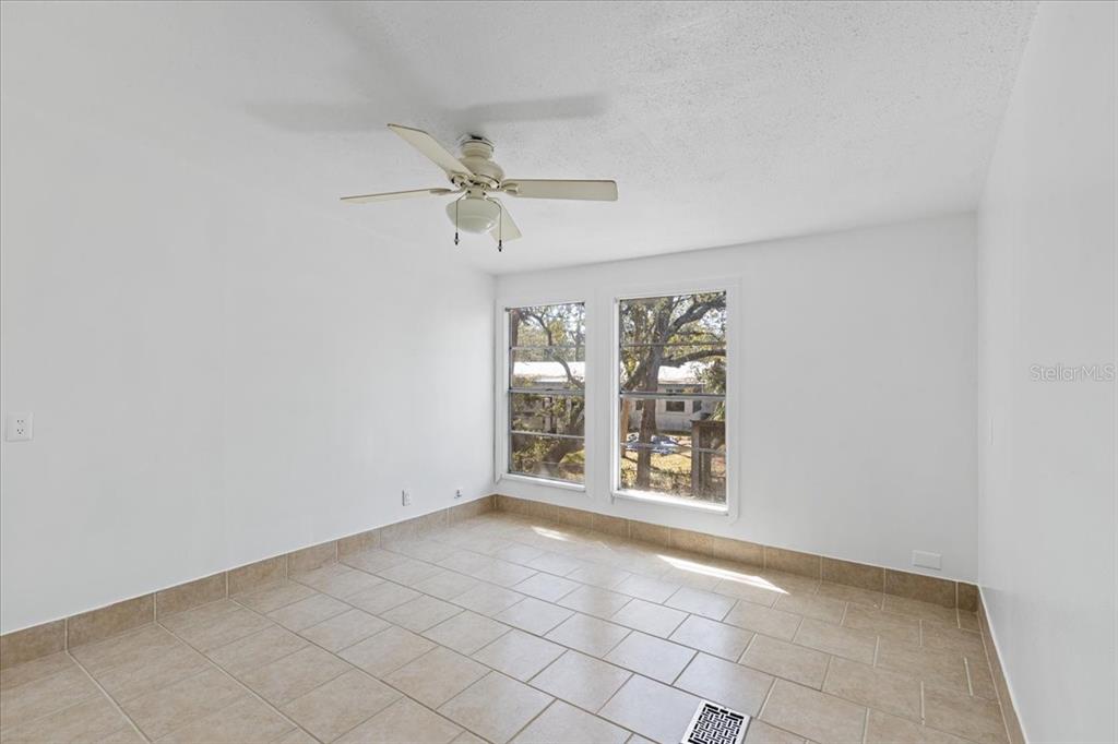 1149 Shell Crest Avenue Cedar Key, FL 32625 - Photo 19 of 32 an empty room with windows and ceiling fan