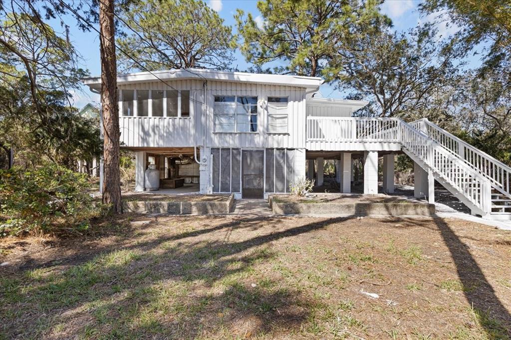 1149 Shell Crest Avenue Cedar Key, FL 32625 - Photo 2 of 32 a view of a house with a large tree and wooden fence