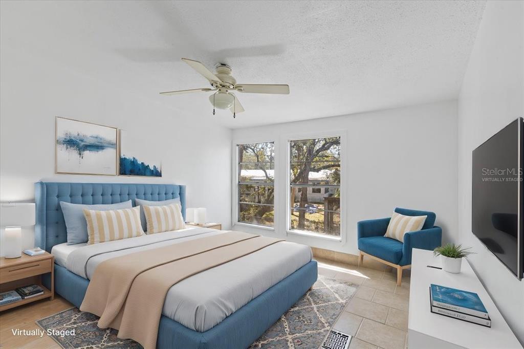 1149 Shell Crest Avenue Cedar Key, FL 32625 - Photo 30 of 32 a spacious bedroom with a bed a couch and a flat tv screen on the dresser