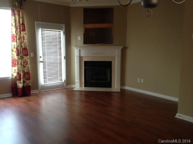 1115 Sienna Sand Way, Unit 111 Fort Mill, SC 29708 - Photo 3 of 15 a view of an empty room with wooden floor fireplace and a window