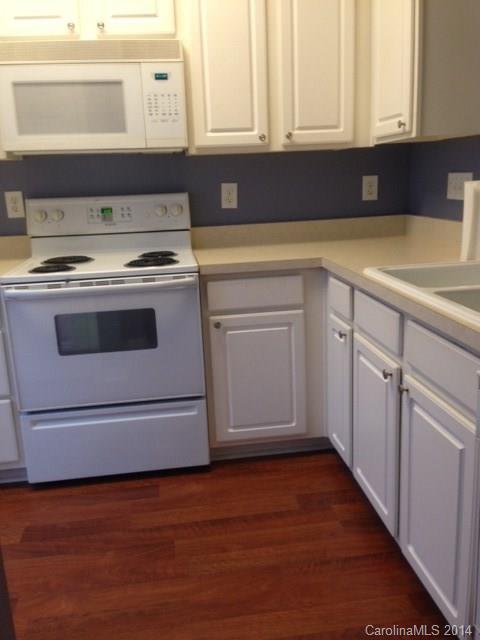 1115 Sienna Sand Way, Unit 111 Fort Mill, SC 29708 - Photo 5 of 15 a kitchen with a refrigerator and mirror