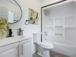 a bathroom with a granite countertop toilet sink and mirror