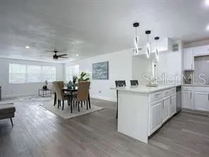 a large white kitchen with lots of counter top space and dining table